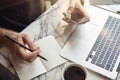 Close-up of manÃ¢â¬â¢s hands using smartphone, making notes, opened laptop sitting in cafe having coffee. Concept of young business Royalty Free Stock Photo